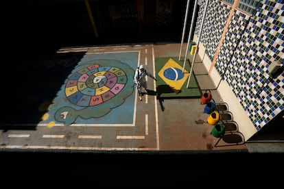 Un operario fumiga el patio de un centro escolar en Brasil.