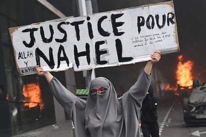 Una mujer sujeta un cartel donde se puede leer 'Justicia para Nahel', durante la protesta en Nanterre, este jueves.