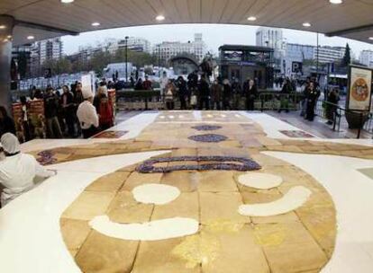 Un grupo de curiosos se aproxima a la galleta gigante de jengibre en Nuevos Ministerios.