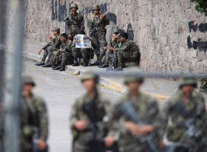 Soldados hondureños se toman un descanso cerca de la Embajada de Brasil en Tegucigalpa.