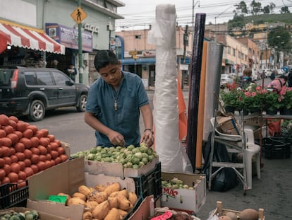 Un vendedor acomoda tomates verdes en un puesto callejero de verduras en la ciudad de Toluca, en el Estado de México.