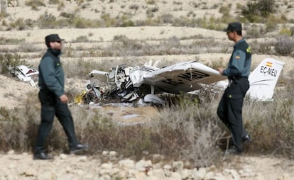 Dos agentes de la Guardia Civil junto a los restos del ultraligero siniestrado en Mutxamel.