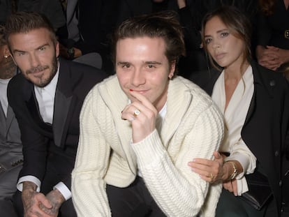Brooklyn Beckham, escoltado por sus padres David y Victoria en un desfile de  Dior Homme Menswear en París en enero de 2020.