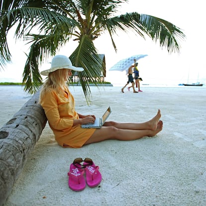 A woman works on her dresser at Villingili beach in the Maldives