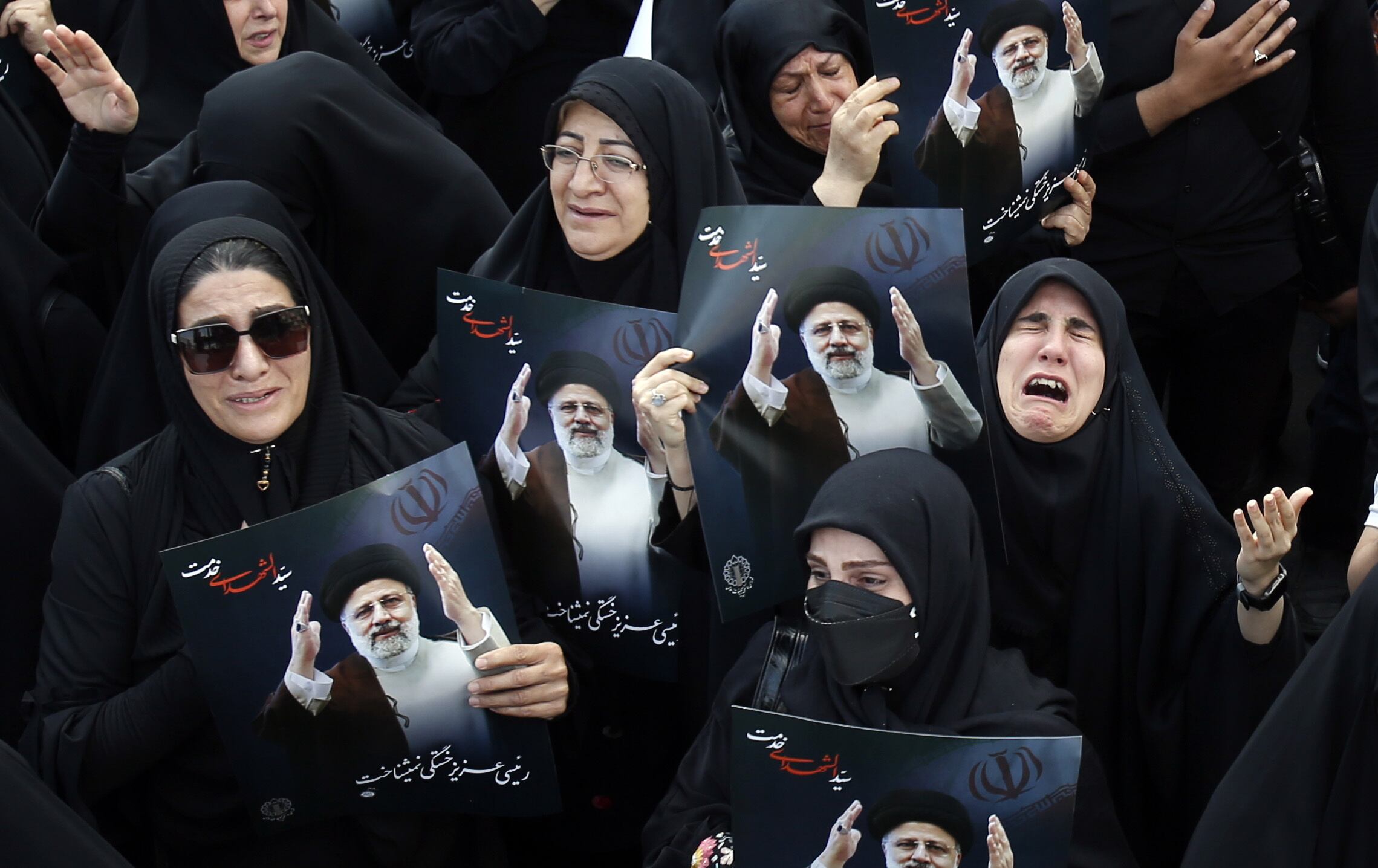 Varias mujeres iraníes sostienen carteles del fallecido presidente iraní Ebrahim Raisí, este lunes en Teherán.