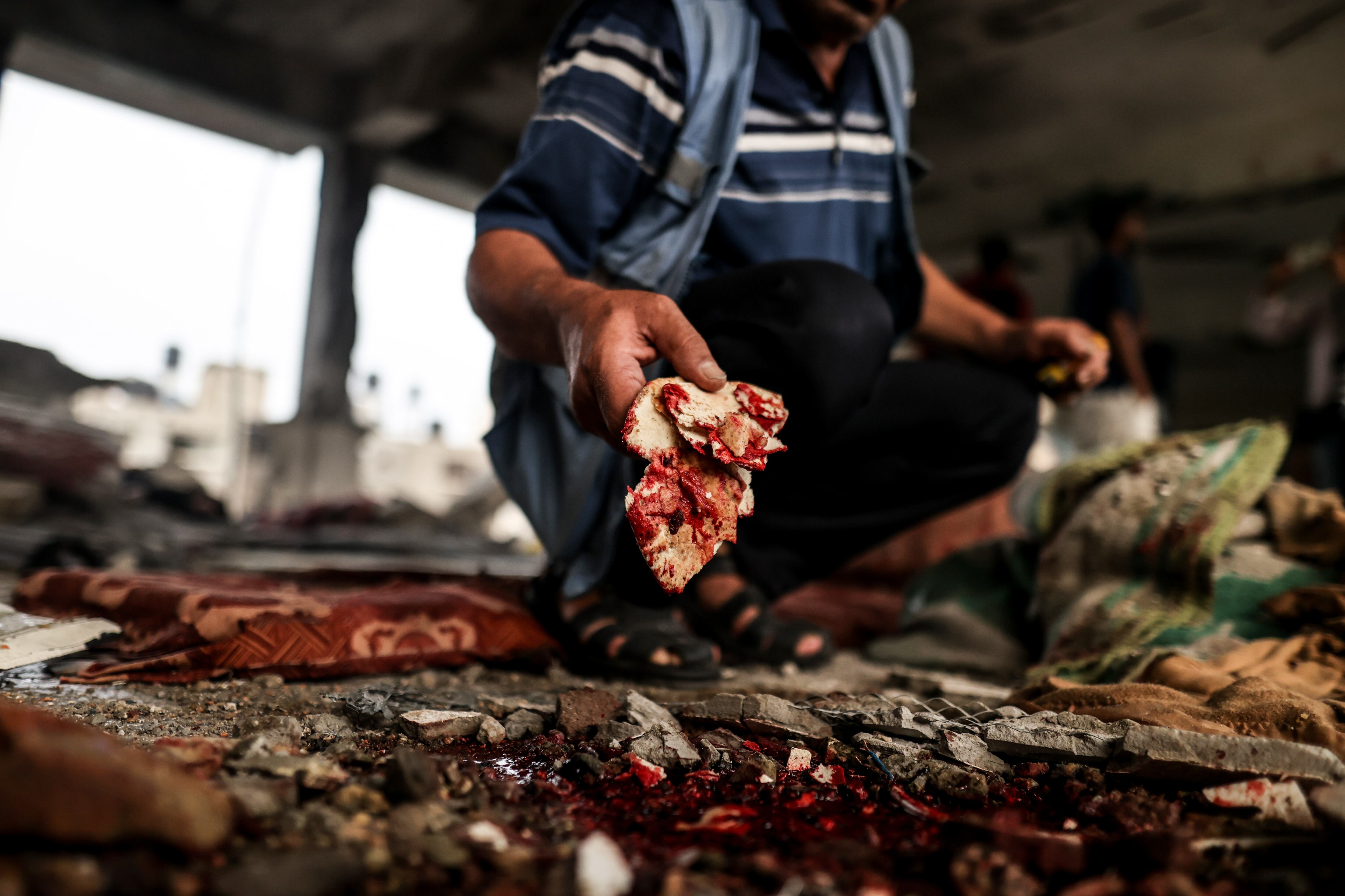 Un hombre muestra restos de sangre en la escuela dañada por el ataque israelí de Nuseirat, en la franja de Gaza.