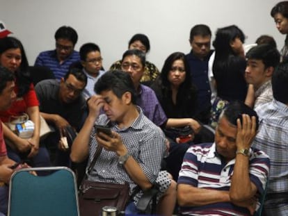 Familiars dels passatgers de l'avió desaparegut esperen notícies a l'aeroport de Surabaya.