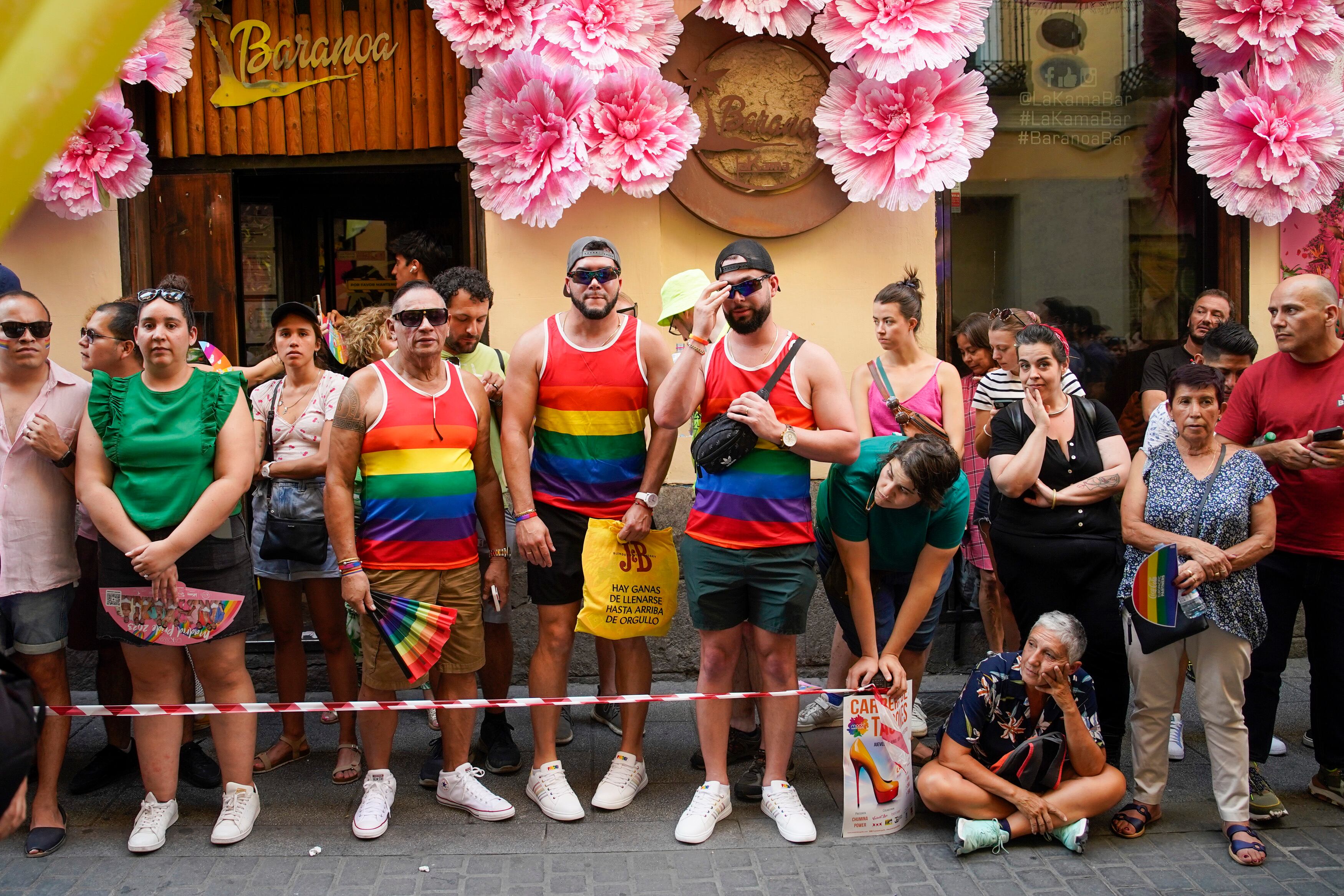 Varias personas esperas el comienzo de la Carrera de Tacones, celebrada en la calle de Pelayo, Chueca, Madrid.