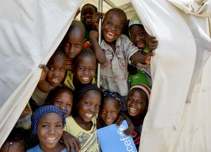 Un grupo de niños sonríen en la entrada de un aula en una tienda de campaña proporcionada por Unicef en el campo Gire 2, cerca de Yola. La organización trabaja con sus aliados y el Ministerio de Educación para garantizar que los desplazados internos tengan acceso a la escuela. Los colegios funcionan en dos turnos para poder acoger a más estudiantes.