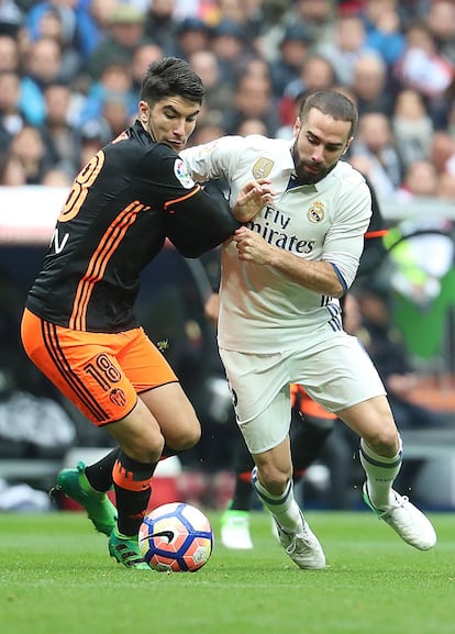 El centrocampista del Valencia Carlos Soler (i) disputa un balón con el defensa del Real Madrid Dani Carvajal (d).