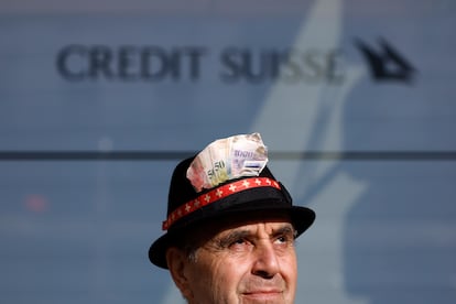 Un manifestante adornaba su sombrero con fotos de billetes de francos suizos a las puertas de la sede de Credit Suisse en Zúrich, el lunes. 