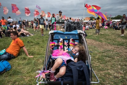 Un bebe duerme en su cochecito, mientras sus padres observan la actuación de la cantante Charli XCX, en Pilton, Inglaterra, el 23 de junio de 2017.