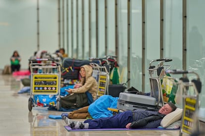 Varias personas duermen en la T4 del Aeropuerto Adolfo Suárez-Madrid Barajas, el 15 de mayo de 2025, en Madrid (España).