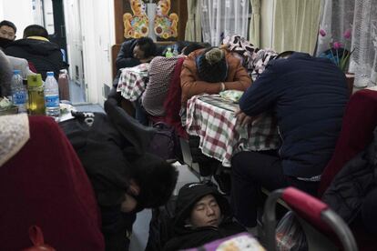 Millones de personas viajan estos días a sus casas desde la capital, pero este año muchas podrían decidir no volver ya que Pekín se está volviendo un lugar cada vez más hostil para la gente que llega de las provincias. En la imagen, pasajeros duermen en el vagón restaurante durante el trayecto.