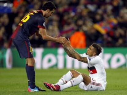 Busquets ayuda a levantarse a Boateng.