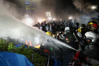 Un manifestante lanza el contenido de un extintor sobre los agentes de la policía que han empezado a desalojar el campus de UCLA. 