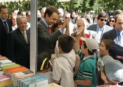 José Luis Rodríguez Zapatero, entre el director de la Feria, Antonio Albarrán, y la ministra Carmen Calvo, ayer en el Retiro.

 / RICARDO GUTIÉRREZ