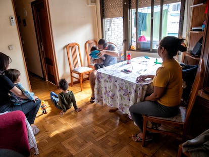 Amanda, sus tres hijos y sus padres, en la sala de su casa en Leganés (Madrid).