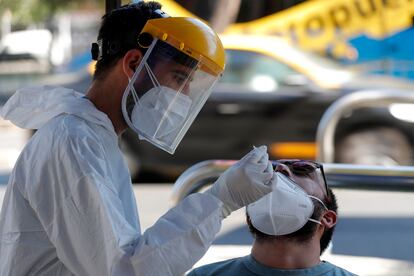 Un trabajador de la salud toma una muestra nasal para una prueba de PCR para detectar la covid-19