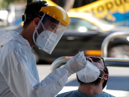 Un trabajador de la salud toma una muestra nasal para una prueba de PCR para detectar la covid-19 en las calles de Santiago, Chile.