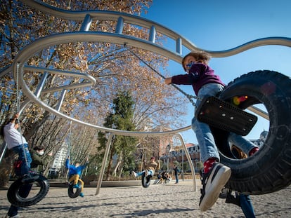 Varios niños disfrutan de los columpios-neumático del nuevo parque infantil de la plaza de España.