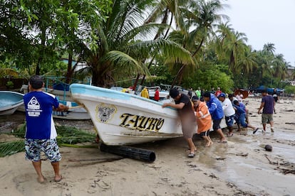 Pescadores y prestadores de servicios turísticos realizan labores de limpieza y rescate en Playa Principal, en Puerto Escondido, este jueves.