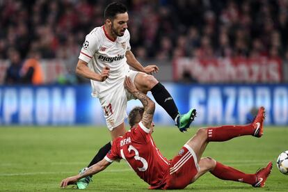 El jugador Rafinha (abajo) de Bayern disputa el balón con Pablo Sarabia (arriba) de Sevilla.