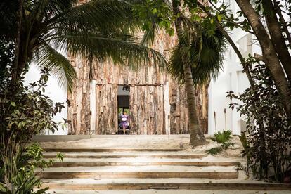 In this image, the entrance of the mansion can be seen, surrounded by luxurious gardens.