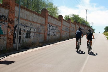 Una via ciclista transcurre junto al muro que impide el paso a las vias del tren.