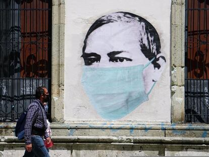 Una pareja camina este lunes junto a un mural alusivo al uso de las mascarillas, en una calle de Oaxaca, en julio de 2020.