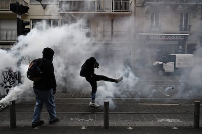Un manifestante lanza un bote de gas lacrimógeno a la policía antidisturbios durante la protesta en Burdeos de este jueves.