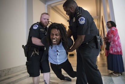 Un manifestante es detenido por la policía del Capitolio durante una protesta contra la reforma del sistema sanitario en Washington (EE UU), el 10 de julio de 2017.