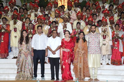 En el centro de la foto, en primera fila, Mukesh Ambani y su mujer, Nita Ambani, posan acompañados de su hijo Akash y su mujer, Shloka Mehta (izquierda), y su hija Isha y su marido, Anand Piramal (derecha). Detrás de ellos posan las 50 parejas de la boda masiva que organizaron en el Reliance Corporate Park, en Bombay. 
