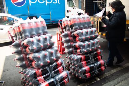 Una mujer recibe botellas de refresco en su negocio en Ciudad de México, el 27 de diciembre de 2022.