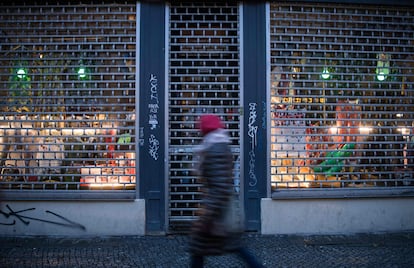 Una mujer pasa frente a la entrada de una tienda cerrada en el distrito berlinés de Kreuzberg este martes.