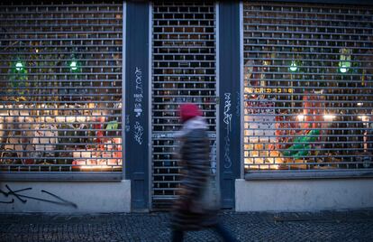 Una mujer pasa frente a la entrada de una tienda cerrada en el distrito berlinés de Kreuzberg este martes.