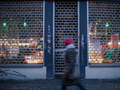 Una mujer pasa frente a la entrada de una tienda cerrada en el distrito berlinés de Kreuzberg este martes.