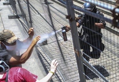 Policial joga spray de pimenta contra os manifestantes.