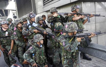 Un docena de soldados esperan para entrar en acción durante la ofensiva lanzada por el gobierno de Tailandia contra el grupo opositor de los <i>camisas rojas</i>.