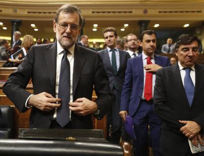 El presidente del Gobierno en funciones y candidato del PP, Mariano Rajoy (centro), abandona el hemiciclo al terminar la segunda jornada del debate de investidura.