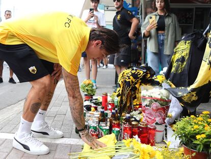 An AEK Athens club soccer player places flowers outside Agia Sophia Stadium, the home stadium of AEK Athens soccer team following clashes between soccer fans, on August 8, 2023.