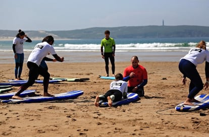 Un grupo de personas que asiste al festival Campeiras aprende a hacer surf junto a un instructor.