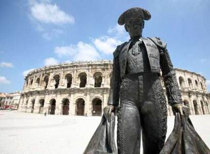 Escultura de un torero ante el anfiteatro romano de Nîmes, convertido en plaza de toros.