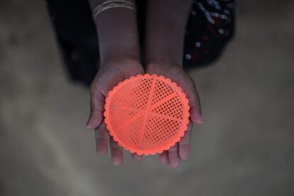 La niña Shawkat Ara, que desconoce su edad, enseña un colador de plástico que usa para jugar con la arena en el campamento de refugiados de Thankhali, en Cox's Bazar.