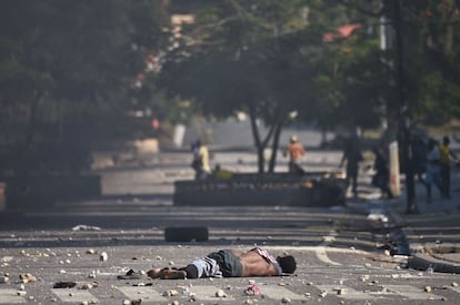 Segundo dados oficiais, as altercações da semana passada deixaram pelo menos 9 mortos. Na foto, o corpo de um manifestante fica em uma estrada em frente ao Palácio Nacional em Porto Príncipe, em 13 de fevereiro de 2019. Os manifestantes levaram o corpo à polícia momentos antes, como forma de protesto.