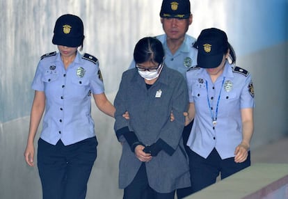 Choi Soon-sil, escoltada por la polic&iacute;a a su llega al tribunal que la ha juzgado en Se&uacute;l. 