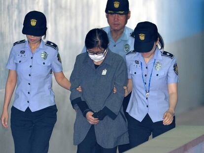Choi Soon-sil, escoltada por la polic&iacute;a a su llega al tribunal que la ha juzgado en Se&uacute;l. 