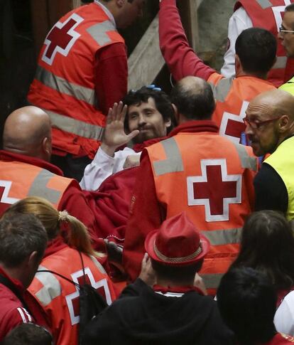 El herido por asta de toro en el muslo derecho es trasladado por efectivos de la Cruz Roja después de ser corneado en el tramo del Callejón.