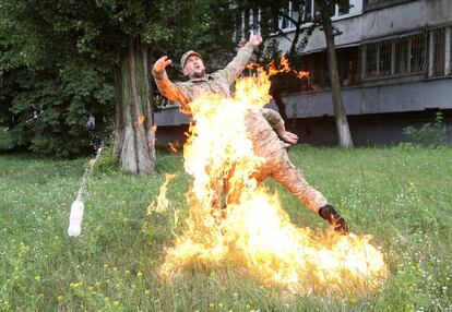 Un oficial intenta apagar las llamas del ex militar ucrainano Serhii Ulianov después de prenderse fuego como protesta por su despido en las Fuerzas Armadas, frente al Ministerio de Defensa, en Kiev. 