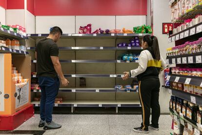 Shoppers surprised by the lack of products at a supermarket in Madrid.